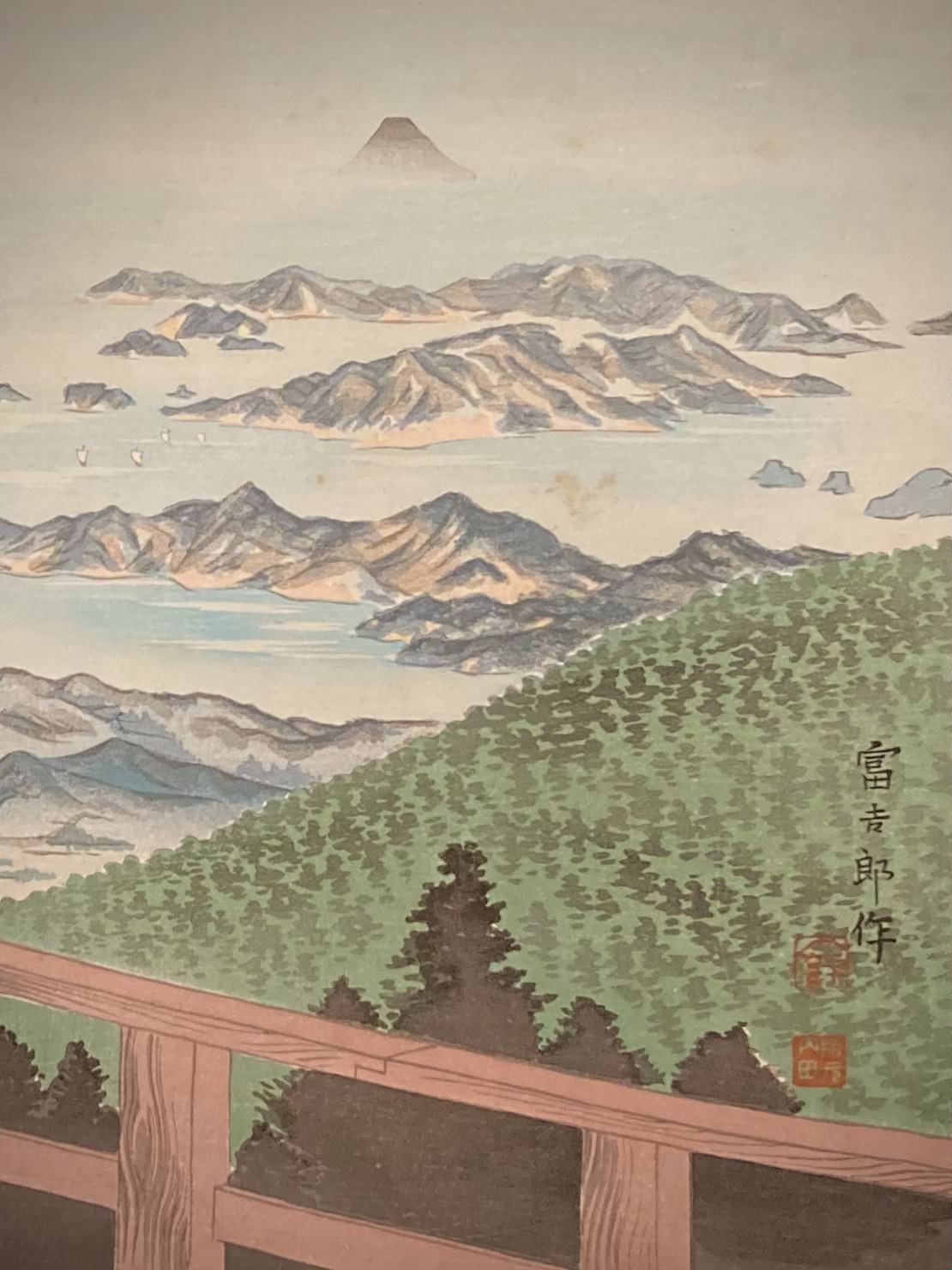 Close-up of wooden railing and layered landscape, emphasizing delicate gradations of sky and distant mountain.
