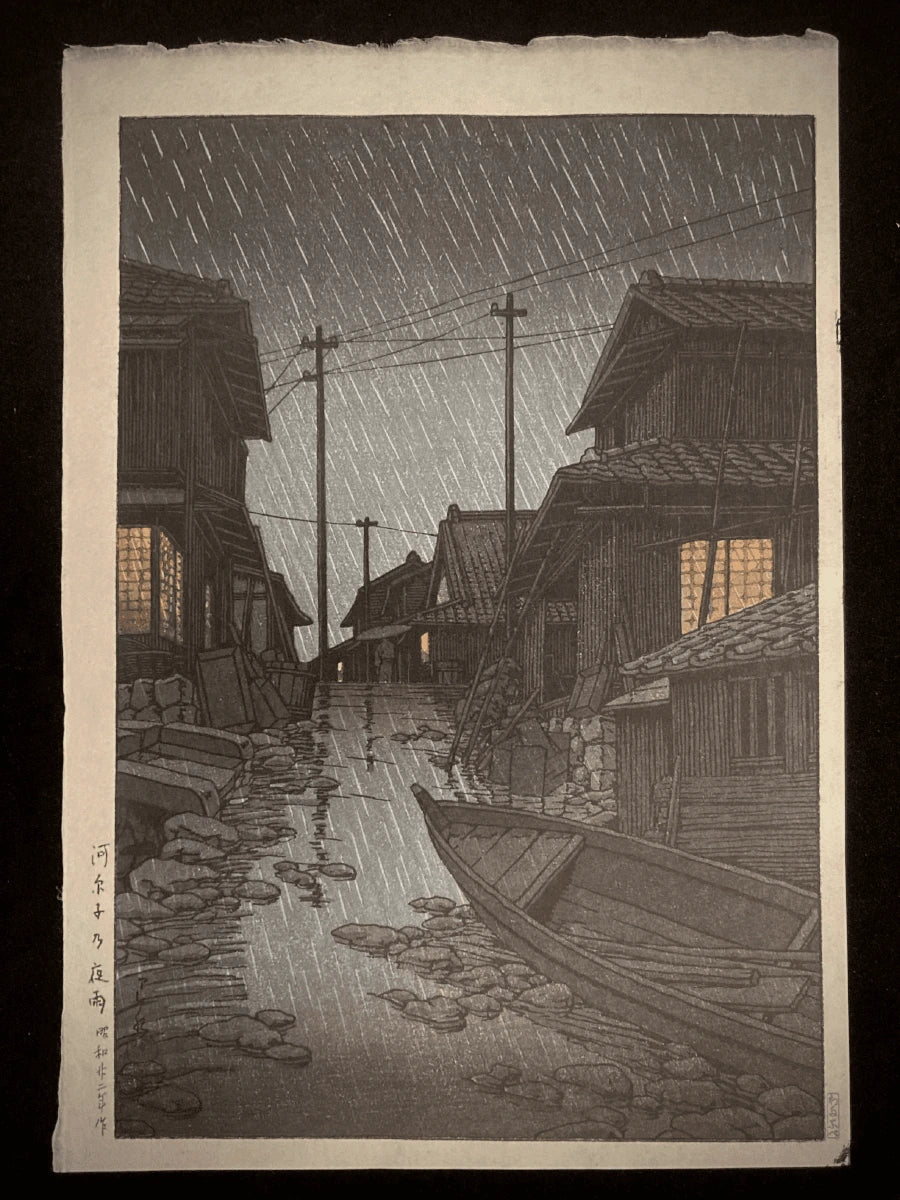 Traditional Japanese rain-soaked alley at night with wooden houses and glowing windows by Kawase Hasui.