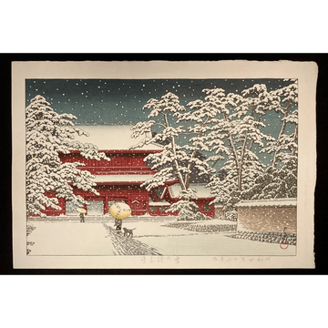 Japanese woodblock print by Kawase Hasui showing Zojoji Temple gate in winter, blanketed in snow with falling flakes and a deep blue night sky.