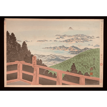 Panoramic landscape with railing in foreground, Mount Fuji on horizon, and scattered islands across calm blue sea.