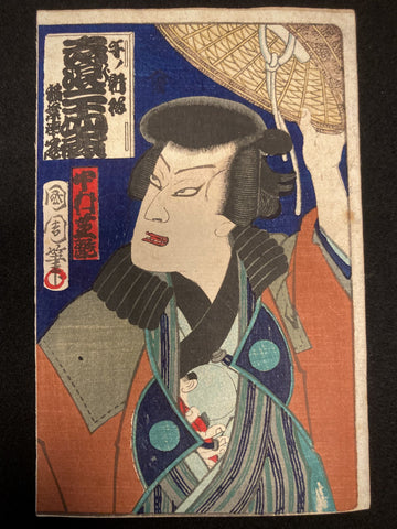 Front view of Toyohara Kunichika’s ukiyo-e print featuring kabuki actor Nakamura Shikan holding a woven kasa hat, set against a dark backdrop.