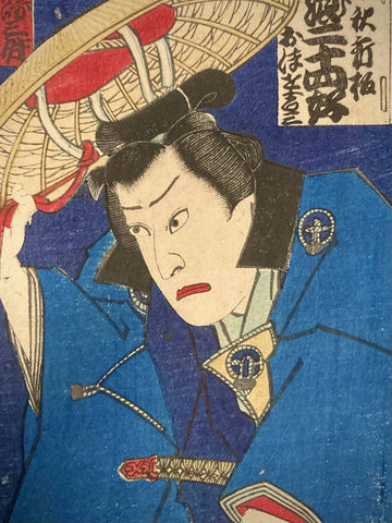 Close-up of Japanese art print highlighting Kabuki actor’s face and hat, with intricate fabric detail and expressive features captured in vivid woodblock lines.