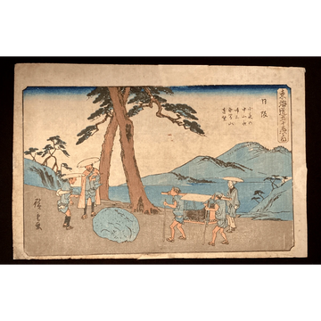 Ukiyo-e Japanese print of travelers on the Tokaido road, featuring a palanquin near water with distant mountains, rendered in soft blue and earth tones.