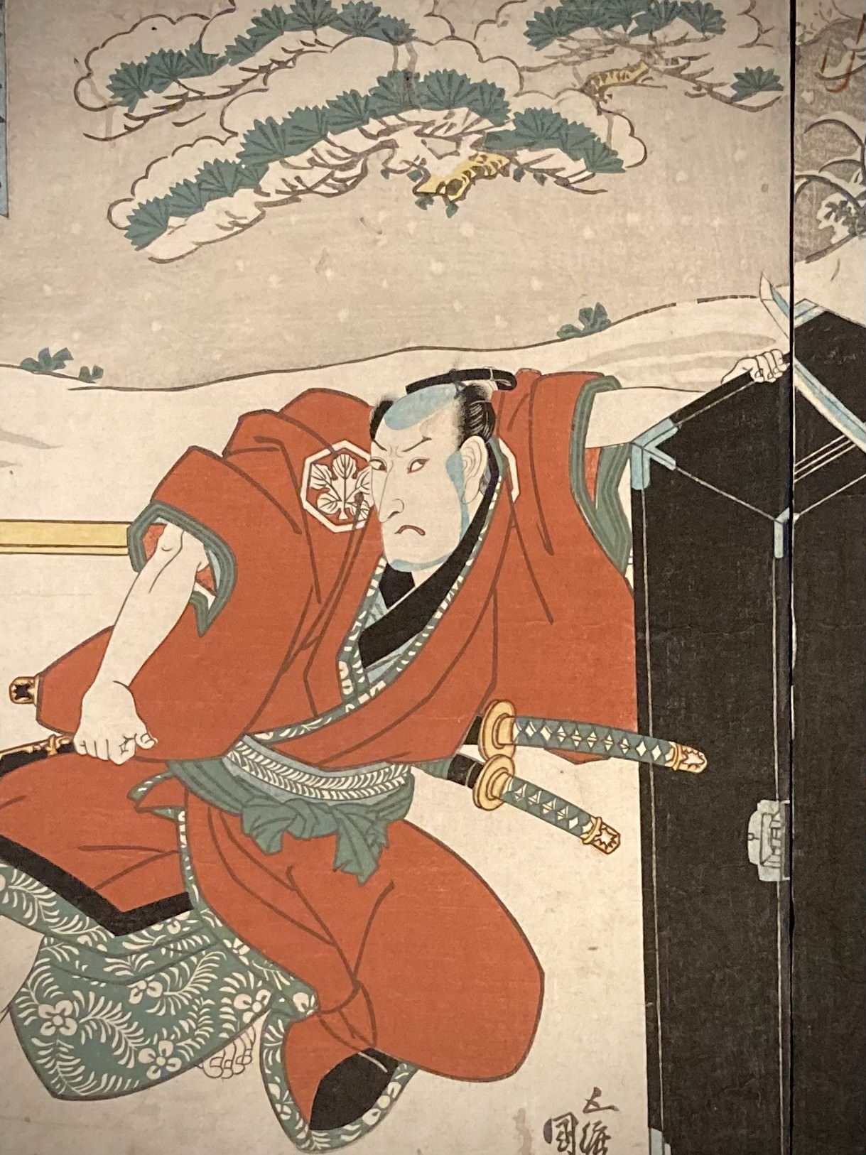 Close-up detail of a samurai in red kimono from Kunisada’s Japanese woodblock print, with snowy setting and intense expression highlighting kabuki drama.